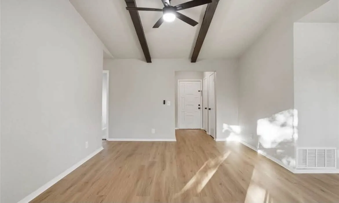 Living room with smooth painted ceiling and dark wood beams